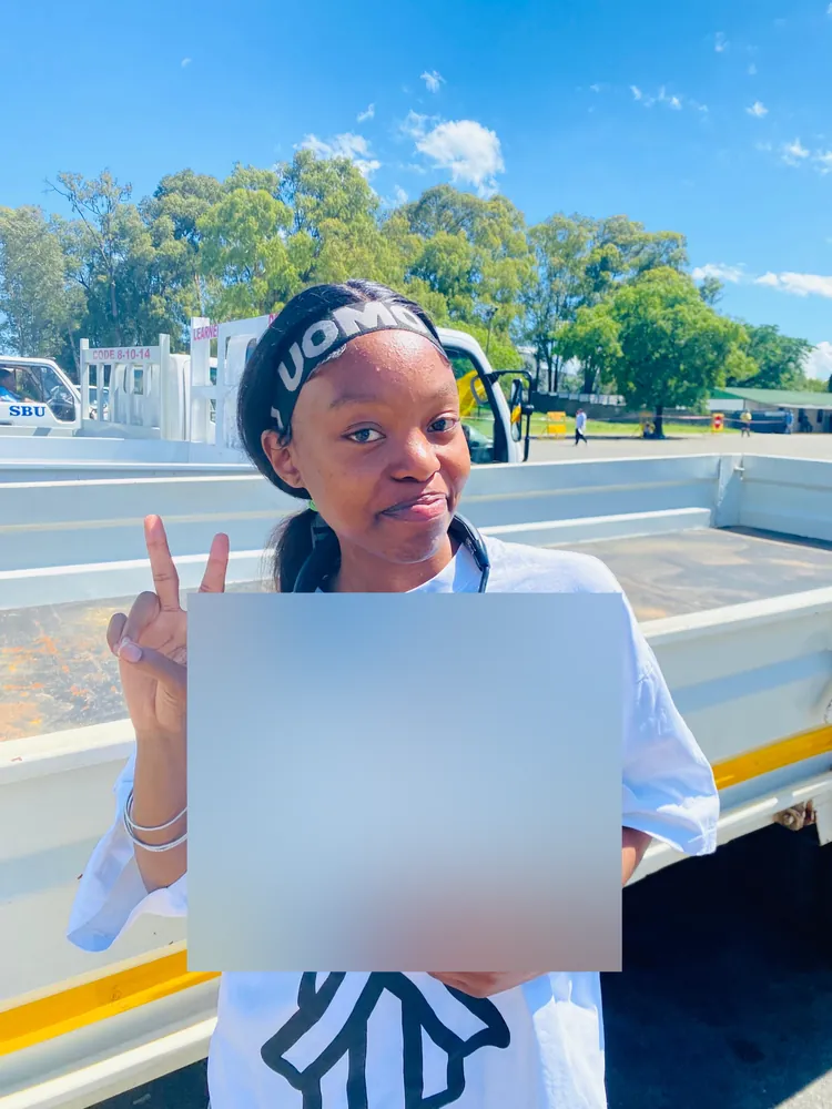 Learner celebrating after passing, beside the training truck