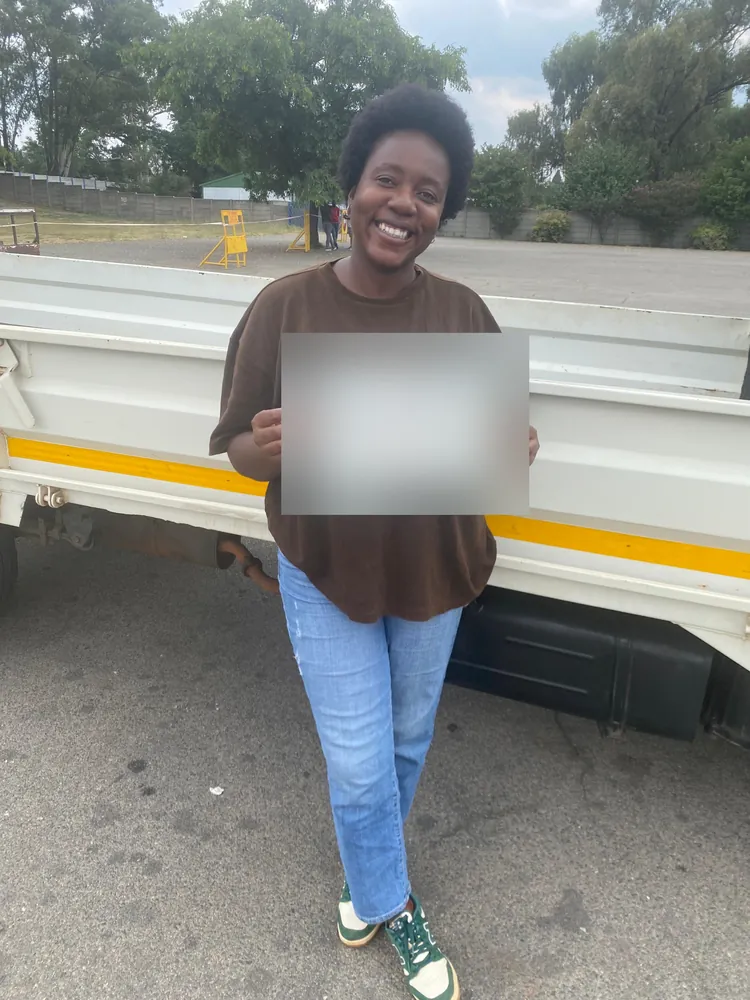 Learner celebrating after passing, beside the training truck