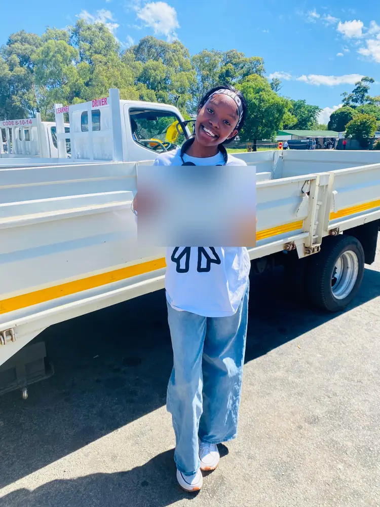 Learner celebrating after passing, beside the training truck