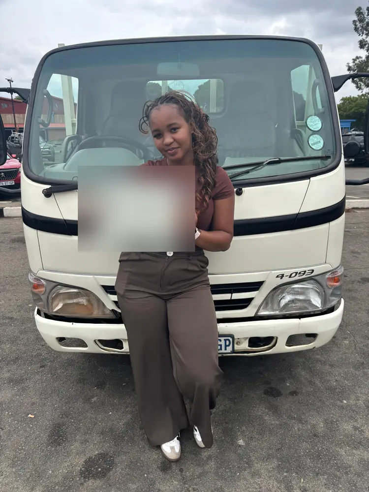 Learner celebrating after passing, beside the training truck