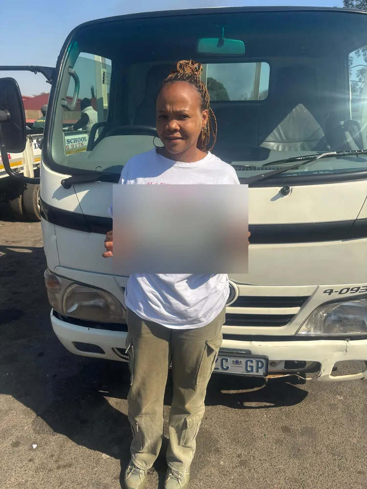 Learner celebrating after passing, beside the training truck