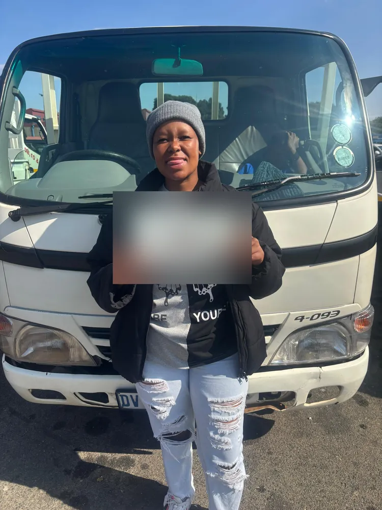 Learner celebrating after passing, beside the training truck