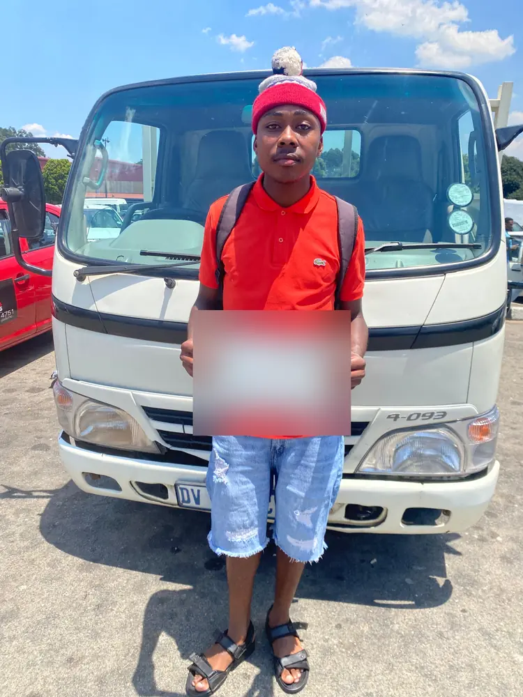 Learner celebrating after passing, beside the training truck