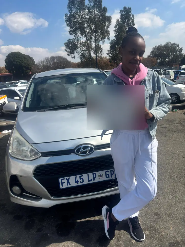 Learner celebrating after passing, beside the training car