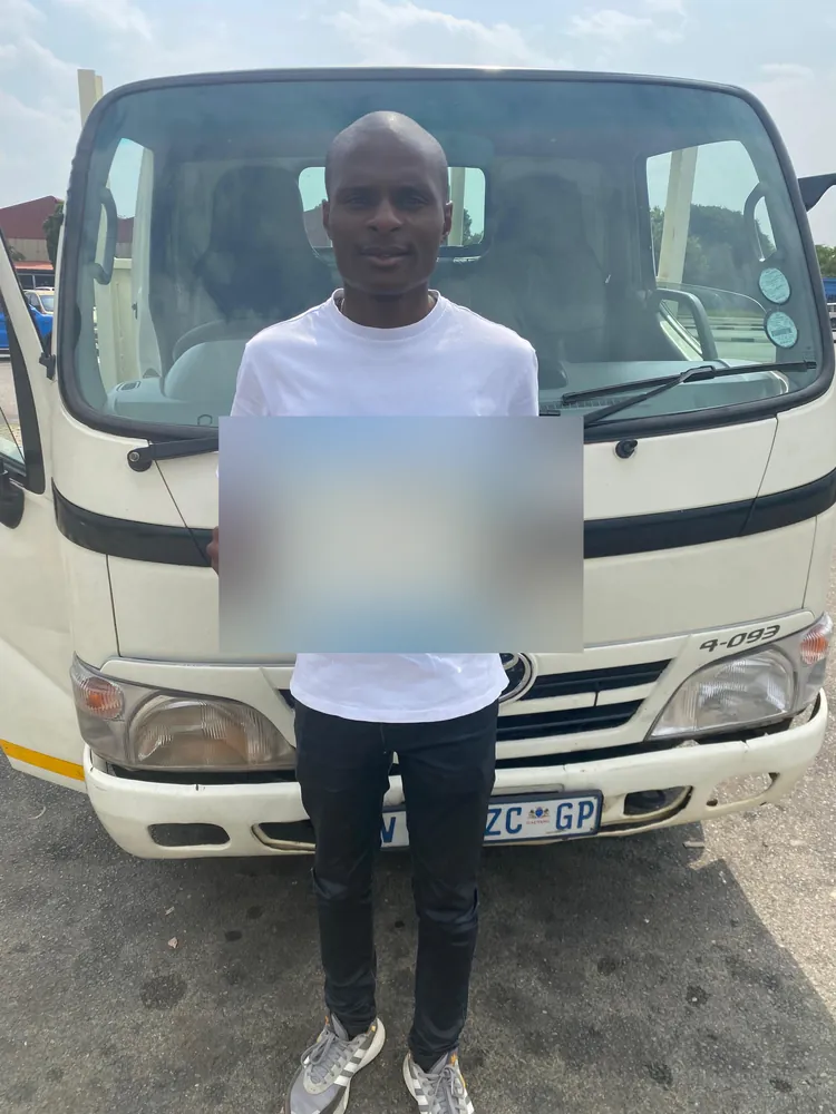Learner celebrating after passing, beside the training truck