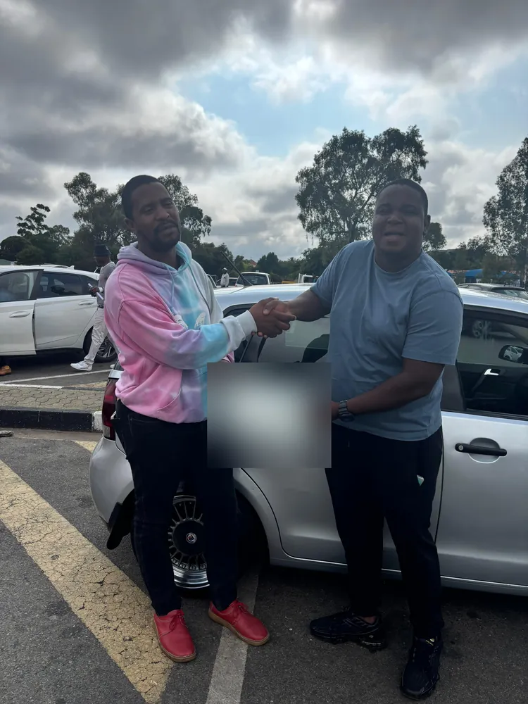 Learner receiving a certificate beside the training car