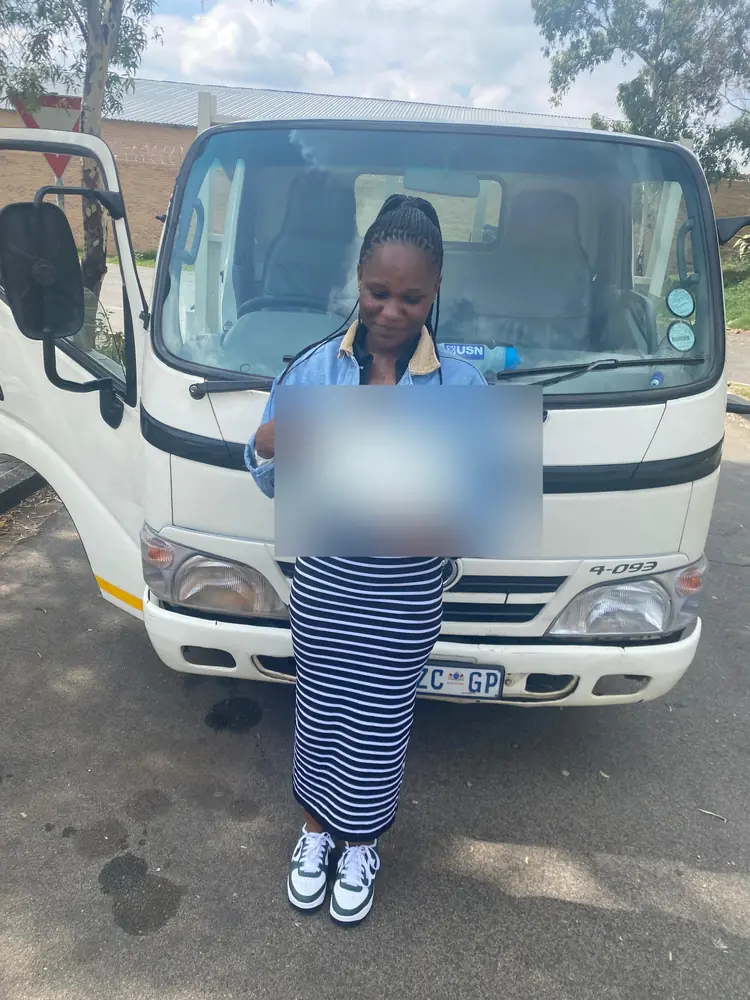 Learner celebrating after passing, beside the training truck