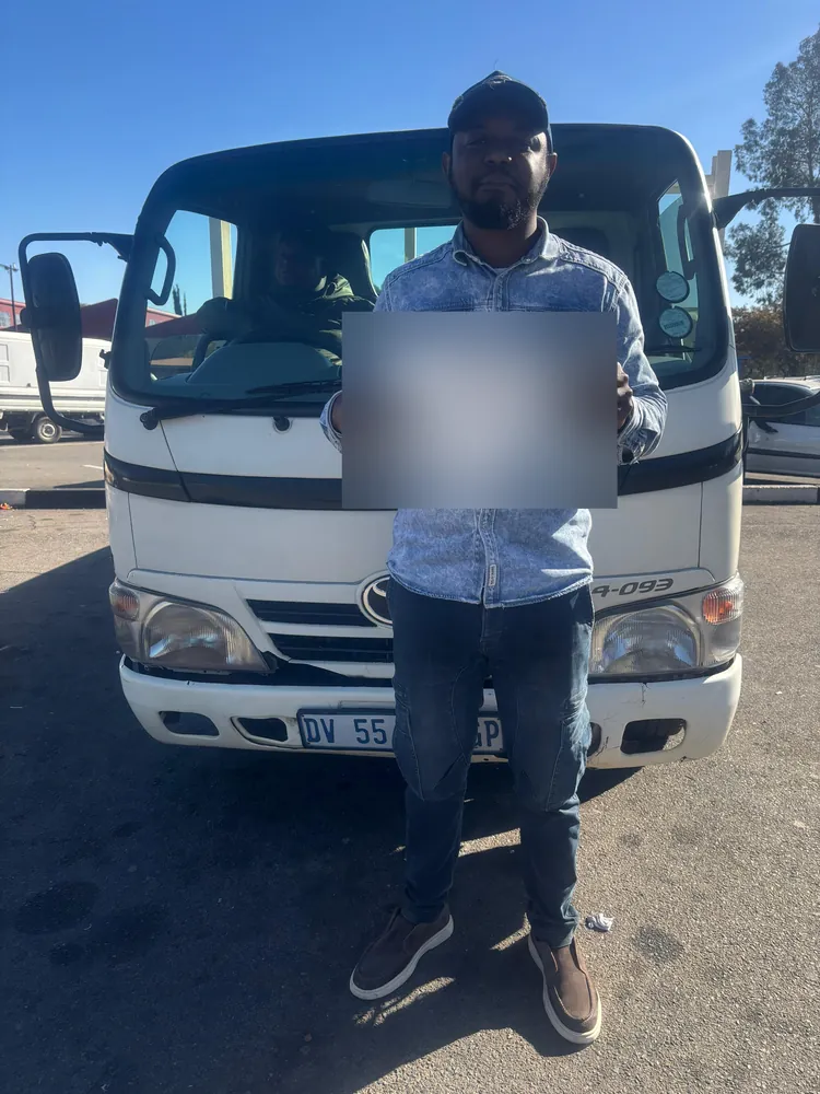 Learner celebrating after passing, beside the training truck