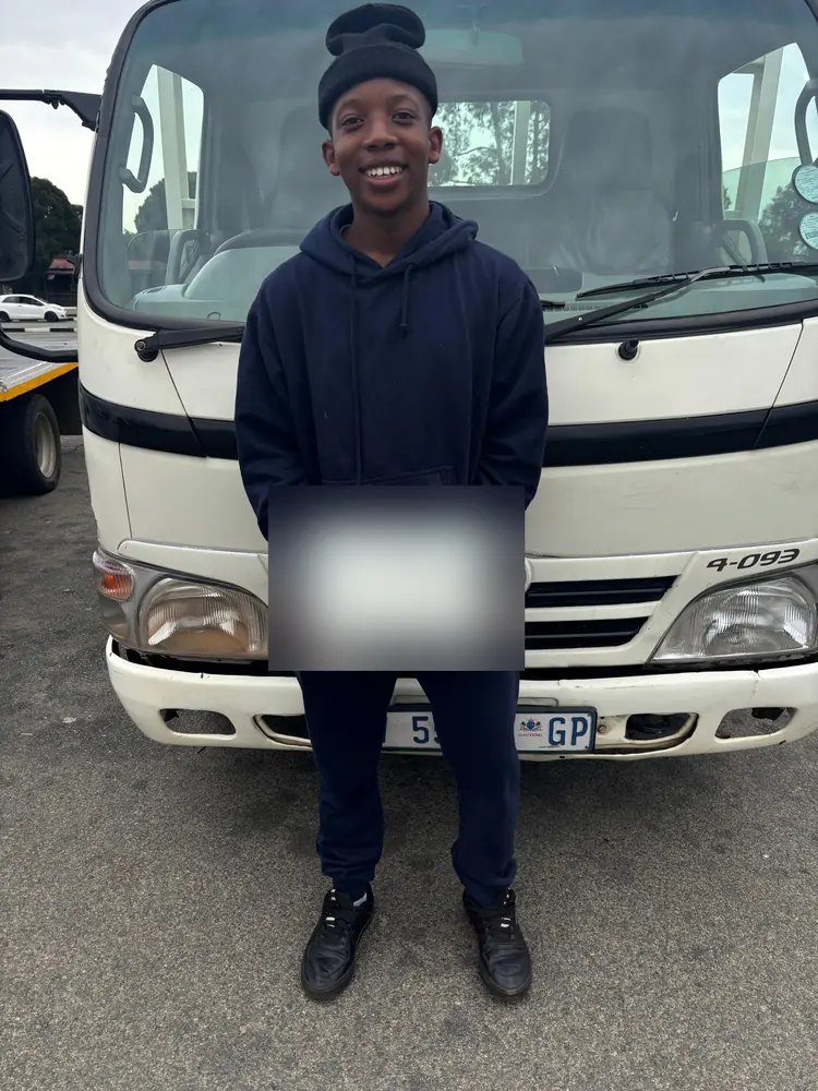 Learner celebrating after passing, beside the training truck