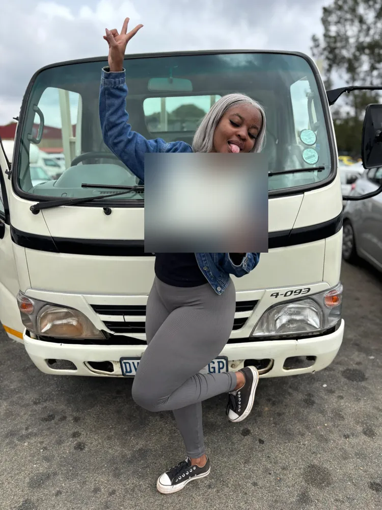 Learner celebrating after passing, beside the training truck
