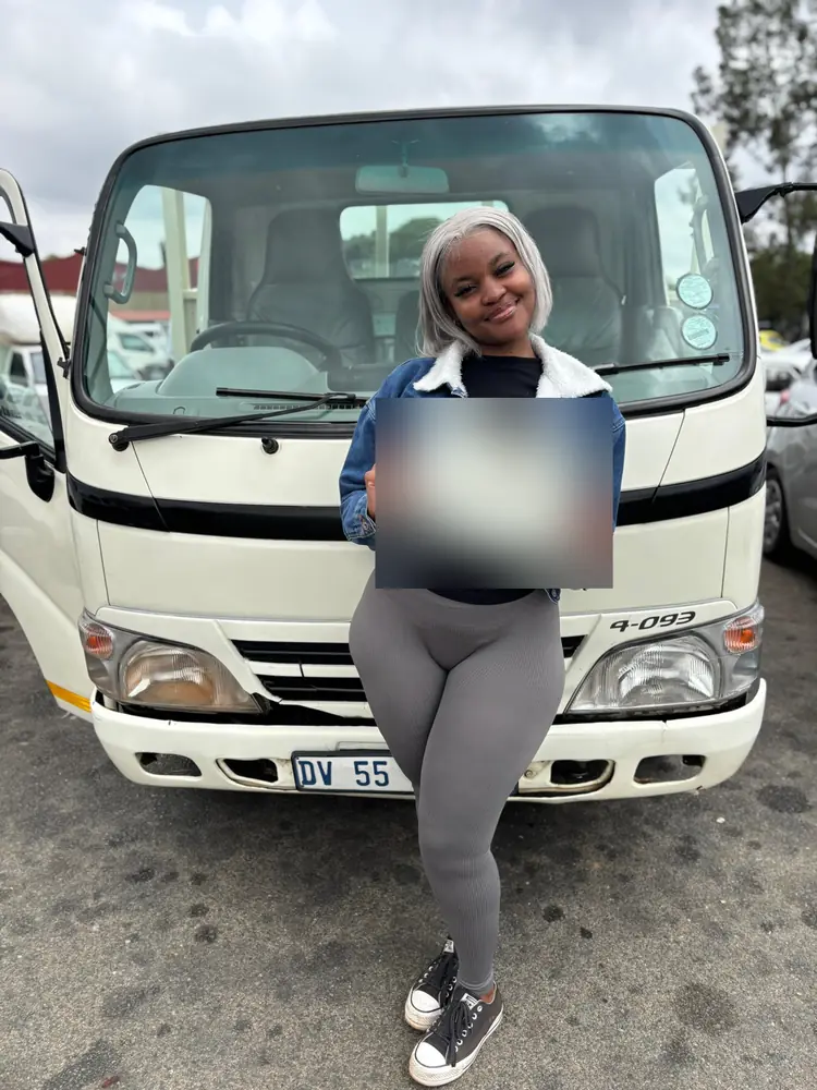Learner celebrating after passing, beside the training truck