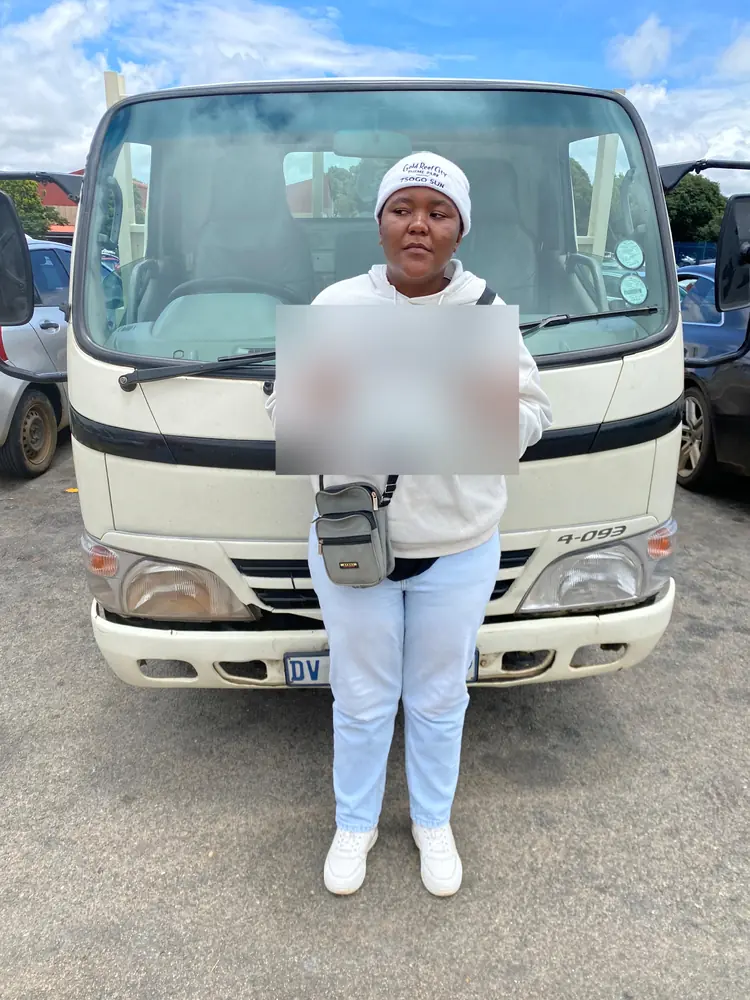 Learner celebrating after passing, beside the training truck