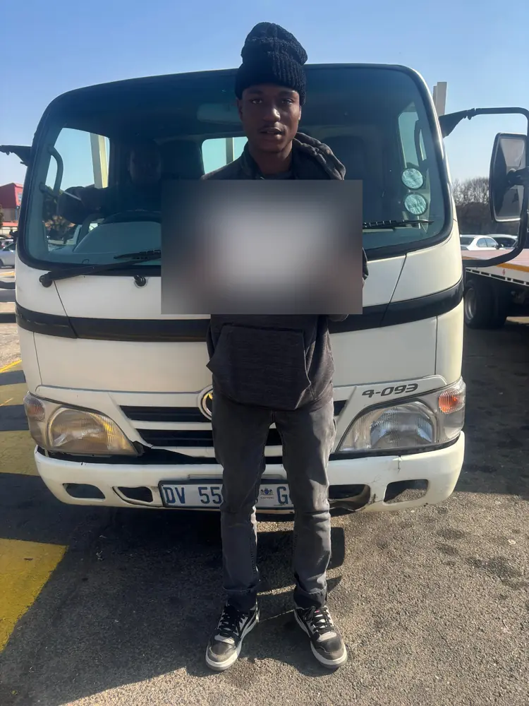 Learner celebrating after passing, beside the training truck