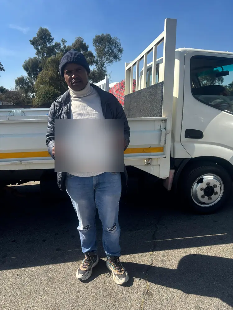 Learner celebrating after passing, beside the training truck